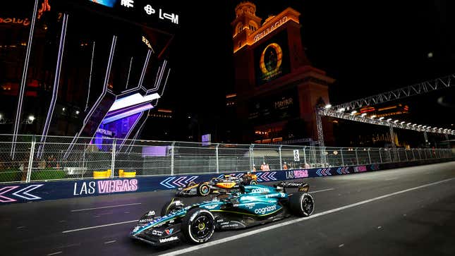 A photo of McLaren and Aston Martin F1 cars racing in Las Vegas. 
