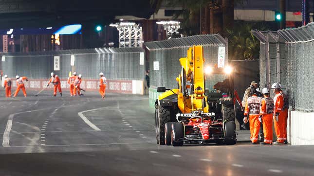 A photo of recovery crews collecting Carlos Sainz's Ferrari F1 car. 